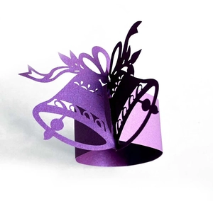 Detailed view of purple laser-cut bell napkin rings with elegant glitter finish