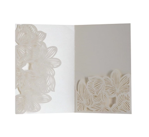 Detailed macro view of an elegant cream-colored laser-cut floral wedding invitation card