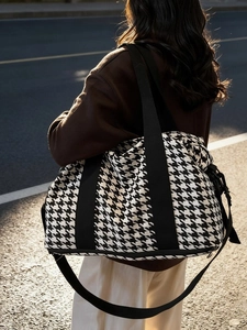 Large houndstooth travel tote bag with black shoulder straps and adjustable cross-body strap
