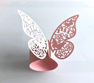 Macro shot of laser-cut butterfly napkin ring with hollow floral patterns in rose gold