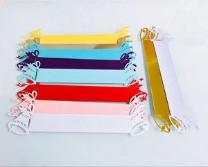 Flat lay of colorful laser-cut paper napkin rings with Christmas bell designs