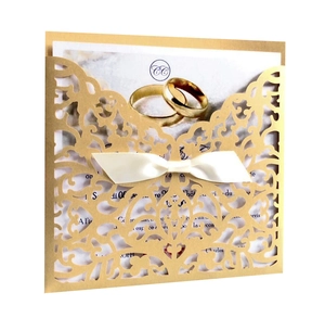 Détail de l'invitation de mariage dorée découpée au laser avec un élégant nœud en satin