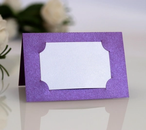 Détail d'un marque-place violet pailleté avec insert blanc pour décoration de mariage