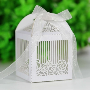 Macro detail of laser-cut rose patterns on white European style hollow wedding favor boxes