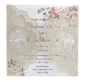 Detail of laser-cut lace wedding invitation with glitter finish and floral inner card