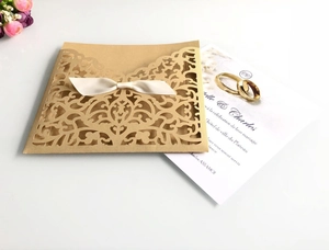 Faire-part mariage découpé laser avec nœud ivoire et motifs anneaux dorés sur papier
