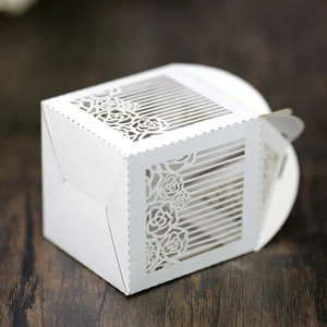 Close-up of laser-cut rose hollow candy box with white pearlescent paper texture