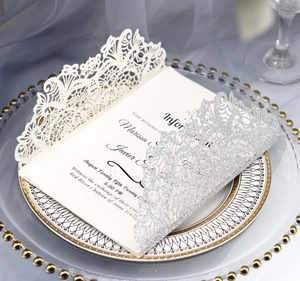 Detailed laser-cut wedding invitation featuring intricate silver glitter lace and card insert