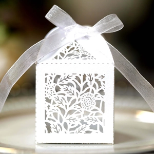 Detail view of laser-cut rose patterns on white wedding gift box with satin ribbon
