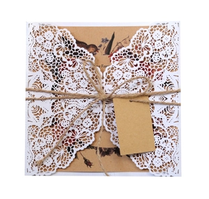 Detail of laser-cut lace invitation with kraft paper insert and rustic hemp rope bow