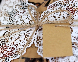 Macro detail of laser-cut lace card with natural twine and rustic kraft paper tag