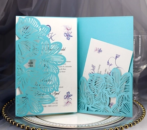Detail of blue laser-cut wedding invitation with intricate floral lace on elegant porcelain