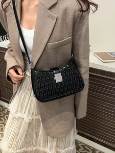 Minimalist black woven shoulder bag with chain strap and metal clasp on female model