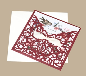 Détail de l'invitation bordeaux découpée au laser avec insert floral et ruban de satin