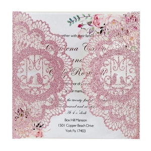 Detail of rose gold glitter wedding invitation with laser-cut lace and bird patterns