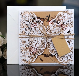 Laser-cut lace wedding invitation with kraft paper inner sheet and twine bow