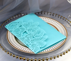 Detail of light blue laser-cut lace invitation card on elegant white vintage plate