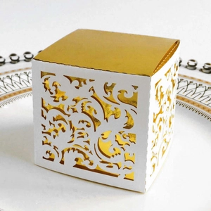 Laser-cut white wedding candy box with gold foil lining and intricate hollow pattern