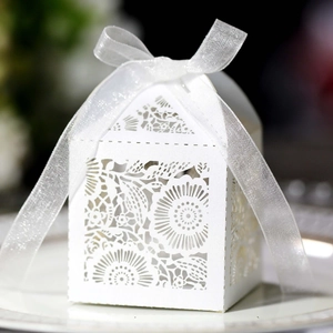 Détail de boîte à bonbons blanche découpée au laser avec dentelle et ruban en organza