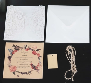Detail of laser cut lace wedding invitation with kraft paper floral card and twine