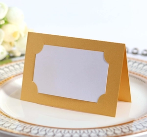 Détail du marque-place doré découpé au laser sur une assiette de mariage pour banquets