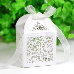 Détail de boîte à bonbons florale découpée au laser avec un élégant ruban blanc et motifs