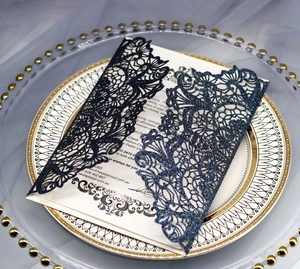 Macro view of laser-cut navy glitter invitation with intricate floral hollow pattern