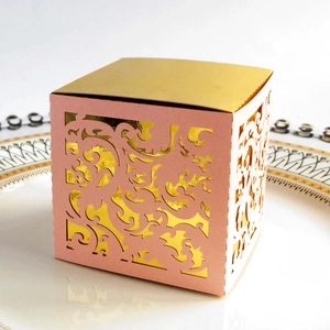 Detail of laser-cut lace floral pattern on pink and gold wedding favor candy box