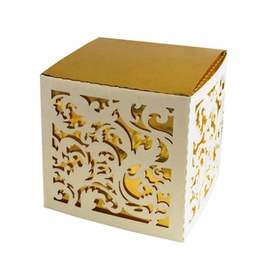 Macro detail of laser-cut paper gift box featuring white hollow patterns and gold foil interior