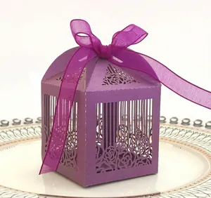 Close-up of laser-cut purple hollow wedding candy box with rose pattern and ribbon