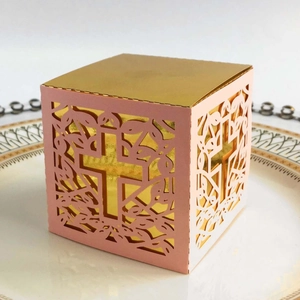 Detail of pink laser-cut hollow candy box with cross pattern and golden inner layer