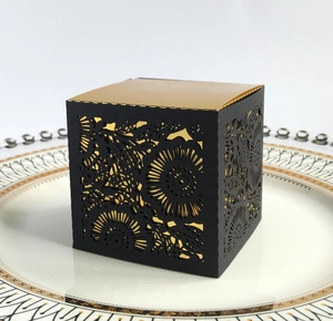 Detail of laser-cut daisy hollow pattern on a black and gold square gift box