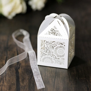 Macro d'une boîte à bonbons blanche découpée au laser avec motifs floraux et ruban