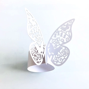 Detail of white laser-cut butterfly napkin ring with intricate floral lace pattern