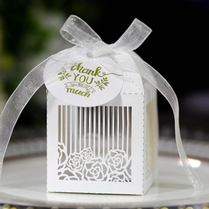 Macro shot of white laser-cut rose gift box with silver ribbon and thank you tag