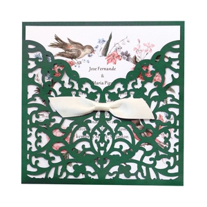 Détail de l'invitation de mariage découpée au laser avec pochette vert foncé et nœud en satin