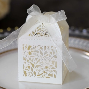 Macro detail of white laser-cut rose floral gift box with a delicate sheer ribbon bow