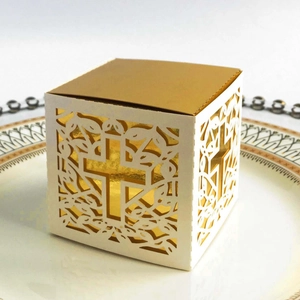 Detail showing laser-cut cross pattern on ivory and gold square wedding favor box