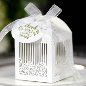 Detail of white laser-cut rose hollow wedding favor box with a thank you tag