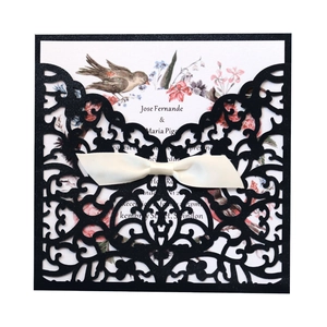 Détail d'invitation de mariage découpée au laser noire avec ruban et carte fleurie