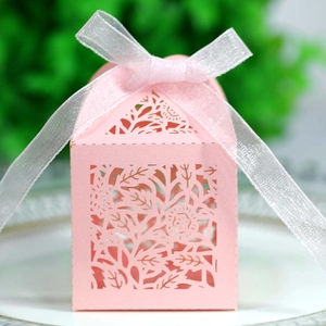 Detail of pink laser-cut floral wedding favor box with a white ribbon bow