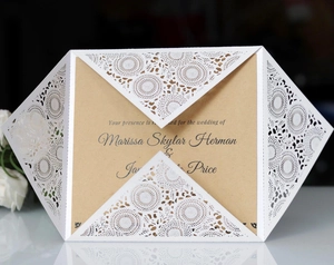 Detail of laser-cut white floral invitation cover with vintage brown kraft paper card