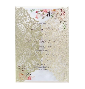 Detailed laser-cut pattern on gold glitter wedding invitation with floral inner card