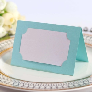 Κομψή κάρτα θέσης γάμου tiffany blue laser cut σε πιάτο με λευκά τριαντάφυλλα