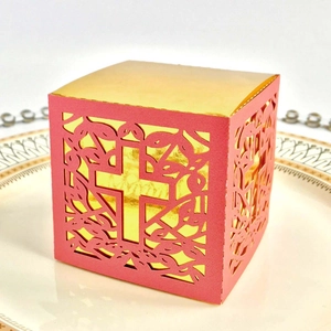 Detail of laser-cut cross pattern on red gift box with gold interior lining