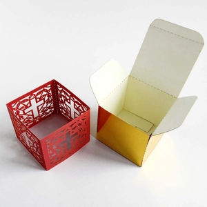 Detail of red laser-cut cross pattern and golden metallic wedding gift box