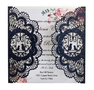 Detail of laser-cut navy blue glitter wedding invitation with floral insert card