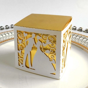 Detailed laser cut wedding candy box with romantic silhouette and gold inner lining