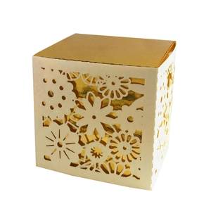 Detail of laser-cut floral patterns on a white candy box with golden inner liner