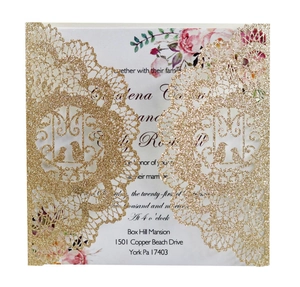 Detail of laser-cut glitter gold wedding invitation with elegant pink floral inner card